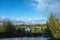 Spring landscape with a beautiful lake with fir trees and last snow against a cloudy sky