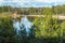 Spring landscape with a beautiful lake with fir trees and last snow against a cloudy sky