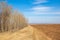 Spring landscape. Freshly plowed field. hilly terrain. trees wit