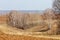 Spring landscape. Freshly plowed field. hilly terrain. trees wit