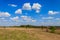 Spring landscape with green trees, meadows, fields and blue sky