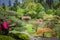 Spring Landscape of Japanese Garden with Pond and Azalea Flowers in Bloom