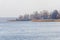 Spring landscape with lake overgrown with reeds near the coast, nature background with dry reed grass