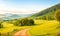 Spring landscape morning in valley with green meadow on hills, orang and blue sky, Spring panorama forest view by the dirt road,