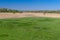 Spring landscape with small round lake in a meadow