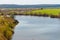 Spring landscape with wide river, field and forest away