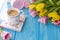 Spring morning, fragrant coffee and tulips of yellow and pink color. Donuttsy copies. Blue wooden background, place for text and