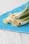 Spring onions in a bunch on a vibrant blue placemat