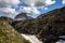 Spring panorama of the green meadows of the Dolomites with snow and pink rocks at the Falzarego pass in Cortina d`Ampezzo Belluno