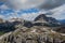 Spring panorama of the green meadows of the Dolomites with snow and pink rocks at the Falzarego pass in Cortina d`Ampezzo Belluno