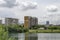 Spring panorama of a part of residential district neighborhood along a lake with green trees, shrubs and flowers, Drujba