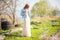 Spring photo of a beautiful young woman on a background of nature. Girl in a light dress and a denim jacket in spring with bloomin