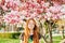 Spring portrait of adorable red-haired preteen kid girl with magnolia flowers