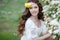 Spring portrait of a beautiful woman in a wreath of flowers