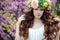 Spring portrait of a beautiful woman in a wreath of flowers