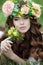 Spring portrait of a beautiful woman in a wreath of flowers