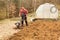 Spring preparation soil for seeding with tiller. Spring work in the garden. Farmer plows the land with a cultivator, preparing it