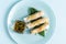 Spring rolls of seafood and vegetables with a decor of green leaves .