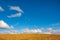 Spring rural landscape. Golden grass, blue sky and heap  beautiful clouds.