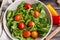 Spring salad closeup with fresh green rocket, spinach leaves and