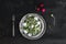 Spring salad with sunflower sprouts and radish in vintage metal plate over rustic dark painted background