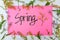 Spring season welcome greeting poster in pastel pink color with flowers border. Start of springtime