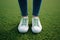 Spring selfie Feet in white sneakers on green grass background