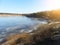 Spring shore of Bay in forest with remains of melting ice floes on Sunny day