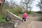 In the spring of small rural girl carries a wheelbarrow.