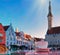 Spring street cafe in Tallinn old town medieval  tower on square , cup of coffee and sunglasses on table top view,sunset  in histo