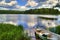 Spring summer landscape blue sky clouds river boat green trees in Sweden