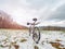Spring trip with steep mountain bike in snowy landscape.  White mtb