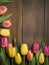 Spring Tulip Border on Vintage Green Wooden Background, Pink and Yellow Flowers, Copy Space