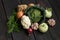 Spring vegetables on a dark background: Savoy cabbage, cauliflower, onion, garlic, kohlrabi, celery root, dill