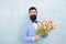 Spring vibes. Man bearded suit bow tie hold tulip flowers bouquet. Gentleman romantic surprise for her. Flowers delivery