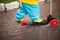 Spring walks in any weather. the child rides a scooter through puddles in rubber boots and a waterproof suit, splashing water in