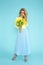 Spring Woman. Beauty Summer model girl with colorful clothes, holding a bouquet of spring flowers. Beautiful lady with yellow