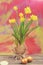 Spring yellow narcissus, golden easter eggs on colorful background