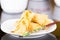 Springrolls elegantly placed on white plate with some soya sauce covering, chopsticks lying across