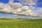 SPRINGTIME. Hilly landscape with fields of wheat immature, dominated by clouds.Italy