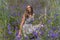 Springtime portrait of brunette girl into meadow violet flowers