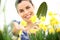 Springtime, smiling woman in garden takes care of flowers