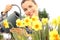 Springtime, smiling woman in garden watering flowers