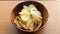 Sprinkle salt on a pile of potato chips in a wooden bowl