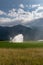 Sprinkler and irrigation system on a freshly planted agricultural field under a cloudy expressive sky with the morning sun shining