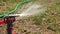 Sprinkler is spreading the water over dry grass in slomo