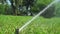 Sprinkler system watering grass in park