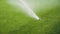 Sprinklers spraying water on the grass in football field