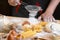 Sprinkles flour chef preparing pasta, cooking fresh italian uncooked homemade pasta tagliatelle at wooden table, in the hands of t