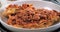 Sprinkling black pepper over delicious lasagne in bolognese sauce